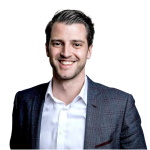 Mann mit kurzen Haaren, grauem Anzug und weißem Hemd, lächelnd vor dunklem Hintergrund. Mann mit kurzen Haaren, grauem Anzug und weißem Hemd, lächelnd vor einem dunklen Hintergrund.